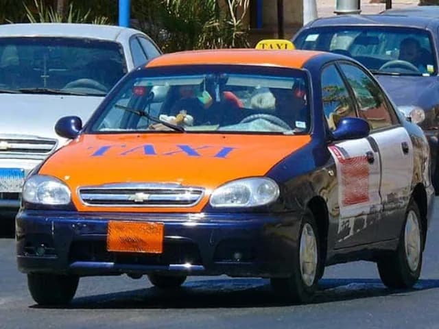 Orangefarbenes Straßen-Taxi in Hurghada im Verkehr